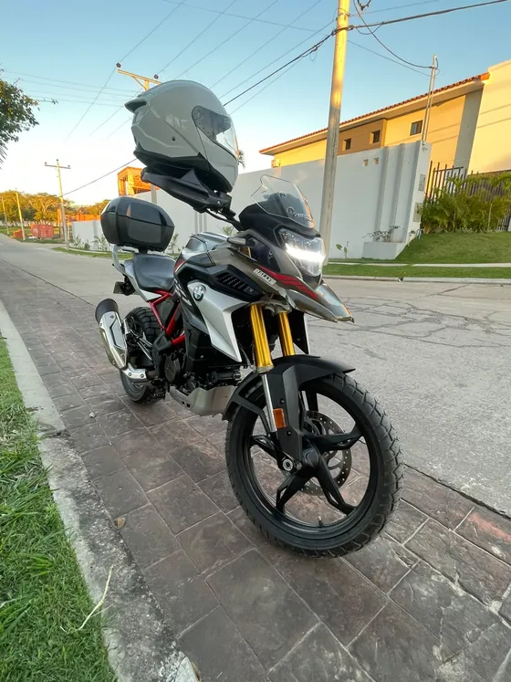 BMW 310 GS de frente en tres cuartos, con faro LED encendido y suspensión invertida dorada