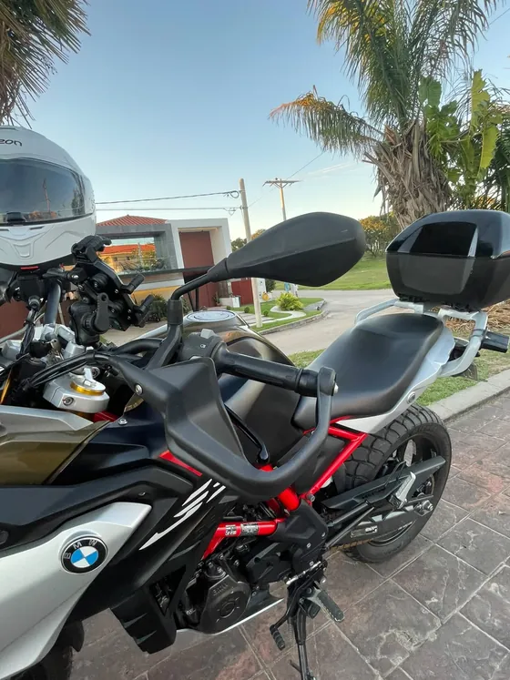 Detalle lateral de la BMW 310 GS con chasis rojo, asiento y Top Case