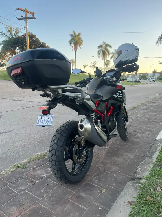 Vista trasera de la BMW 310 GS al atardecer, con escape y llanta trasera nueva