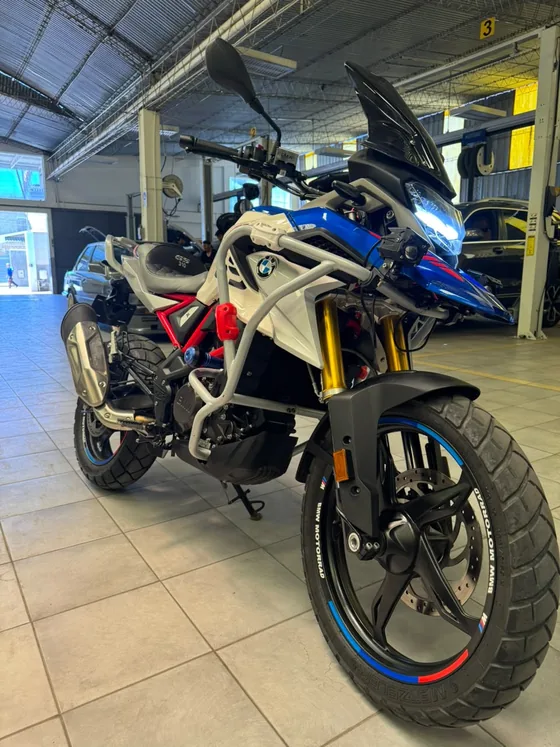BMW 310 GS 2024 de frente en tres cuartos con el faro LED encendido