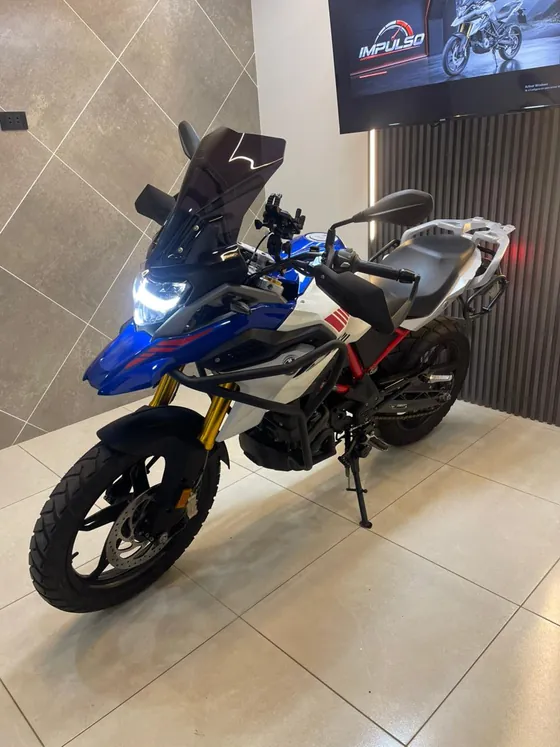 BMW 310 GS 2025 de frente en tres cuartos, con faro LED encendido y suspensión invertida dorada