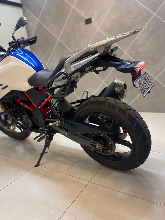Vista trasera de la BMW 310 GS 2025 con escape y soporte lateral para maleta